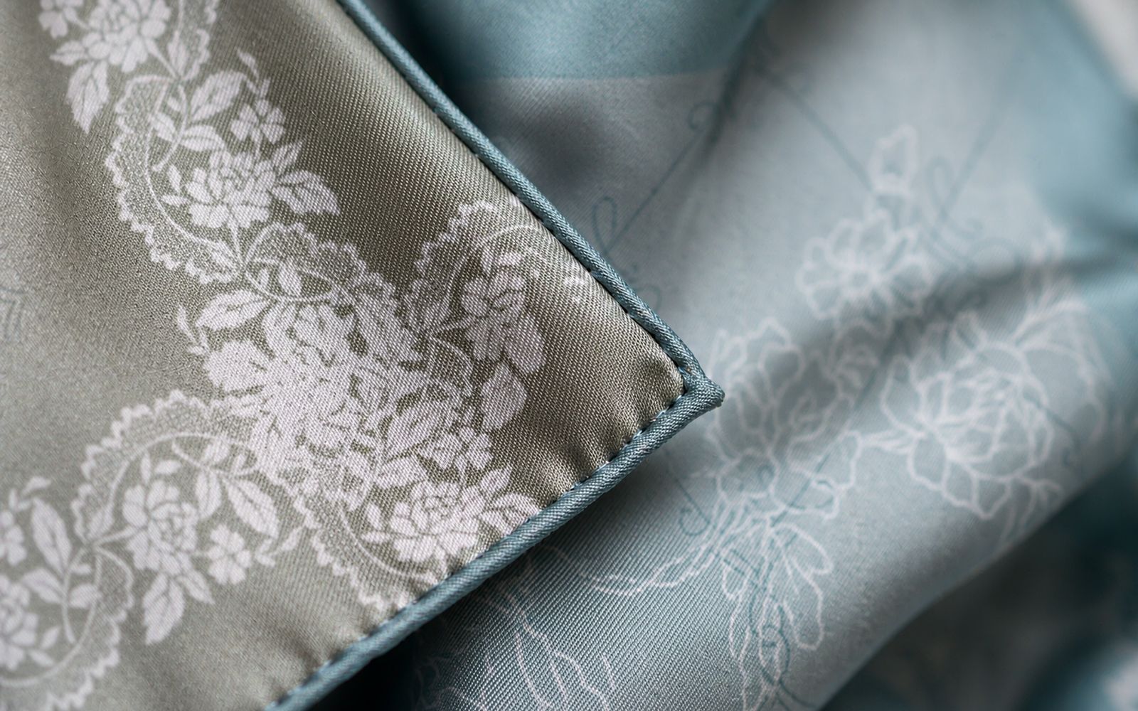 Close-up of the hand-rolled hem and silk twill sheen of an ASYII square scarf
